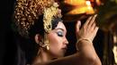 Perempuan berusia 19 tahun ini mengenakan pakaian khas Bali lengkap dengan riasan mahkota emas yang biasa dikenakan perempuan Bali. Dengan riasan wajah bold, ia mengenakan eyeshadow biru dengan lipstik brown. (@thesophiarogan)