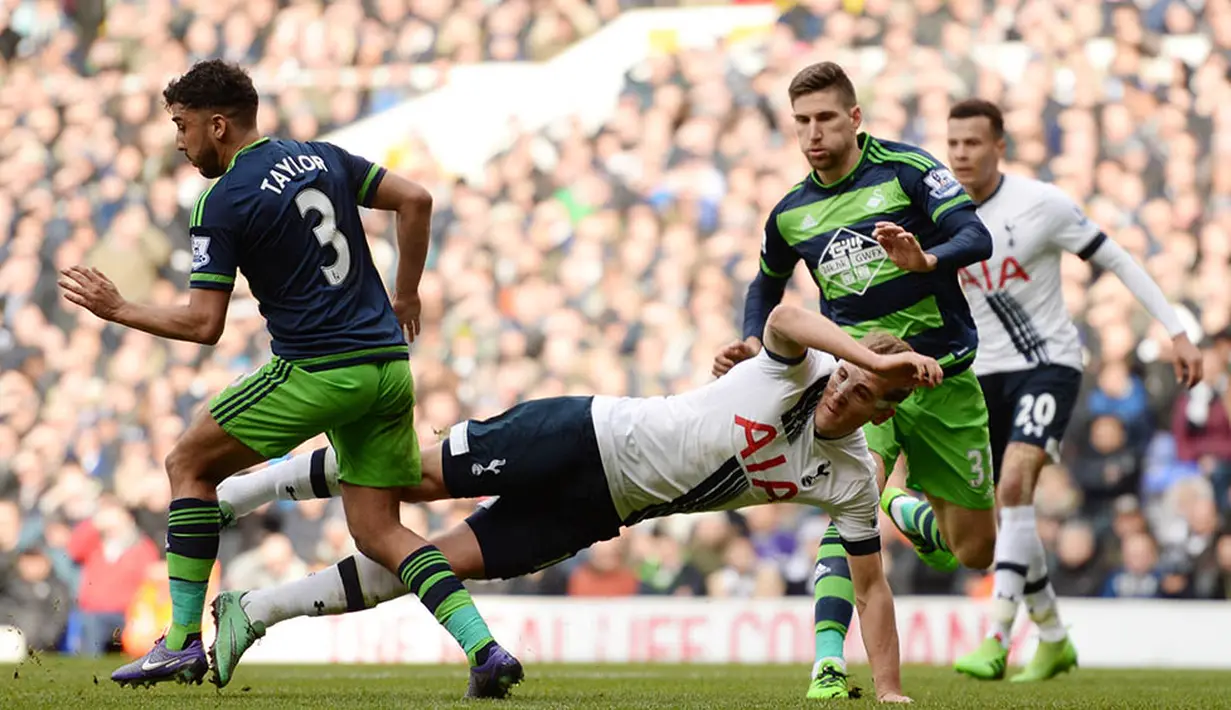 4. Striker Tottenham, Harry Kane, terjatuh berebut bola dengan pemain Swansea, Neil Taylor, pada laga Liga Premier Inggris di Stadion White Hart Lane, Minggu (28/2/2016). Tottenham berhasil menaklukan Swansea 2-1. (Reuters/Tony O'Brien)