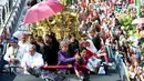 Presiden Joko Widodo (Jokowi) bersama Ibu Negara, Iriana Joko Widodo membagikan kaus dari atas kendaraan hias berbentuk kepala burung garuda pada Karnaval Kemerdekaan Pesona Parahyangan 2017 di Bandung, Sabtu (26/8). (Liputan6.com/Johan Tallo)