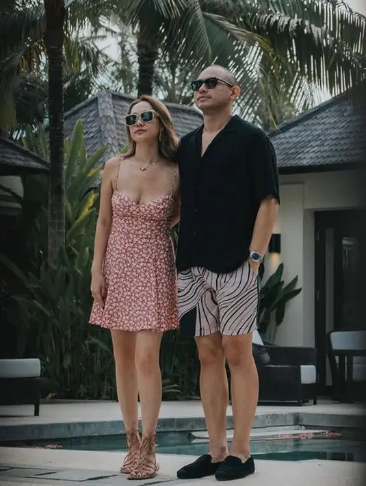 Saat honeymoon di Bali, BCL mengenakan mini dress pink motif bunga-bunga model spaghetti strap. Dipadukan sandal coklat model aligator. [@itismebcl]
