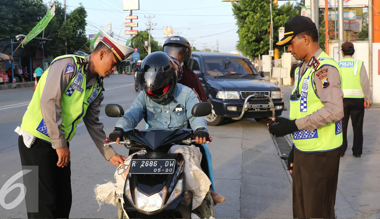 Petugas Kepolisian memberhentikan pengendara motor di Simpang Maya, Tegal, Jawa Tengah Minggu (10/7). Pemberhentian dilakukan untuk mengecek barang bawaan agar tidak membahayakan pengendara lain. (Liputan6.com/Herman Zakharia)