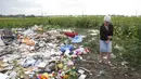 Warga Ukraina yang bersimpati datang ke tempat jatuhnya pesawat lalu meletakkan bunga dan boneka , Ukraina, Sabtu (19/07/2014) (REUTERS/Maxim Zmeyev)