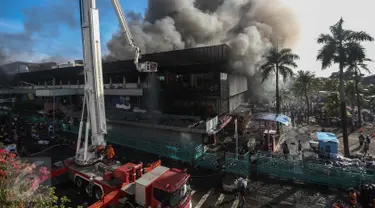 Petugas pemadam berusaha menjinakkan api yang melahap pusat perbelanjaan Pasar Senen, Jakarta Pusat, Kamis (19/1). Kebakaran yang terjadi di Blok III Pasar Senen itu berasal dari api yang timbul dari lantai satu dini hari tadi (Liputan6.com/Faizal Fanani)