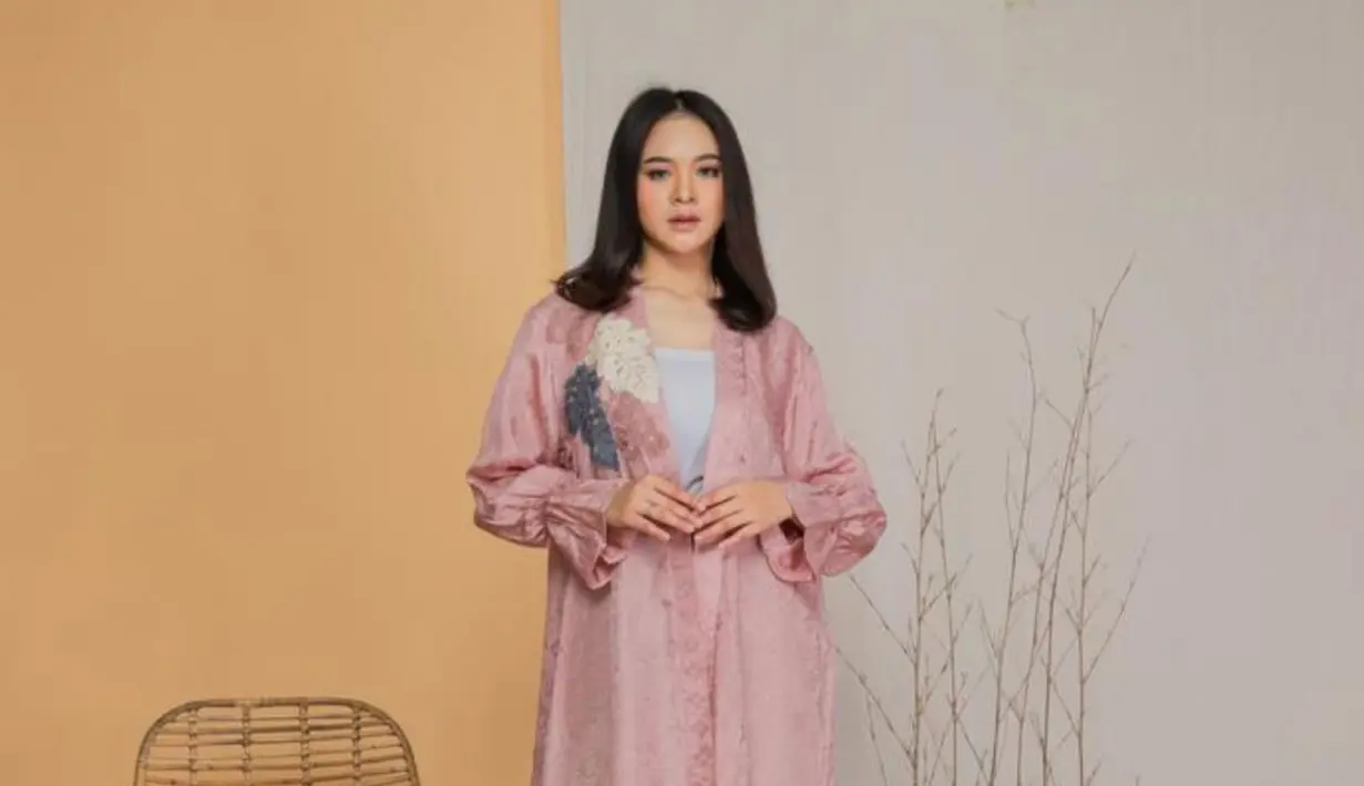 Memadukan kelembutan warna pink pastel dengan detail bordir cantik dan sentuhan brokat yang elegan. Desainnya yang longgar memberi kenyamanan sekaligus kesan anggun, dipadukan dengan kain batik bernuansa biru dan krem yang memperkaya tampilan. [Dok/MAMAUTY]