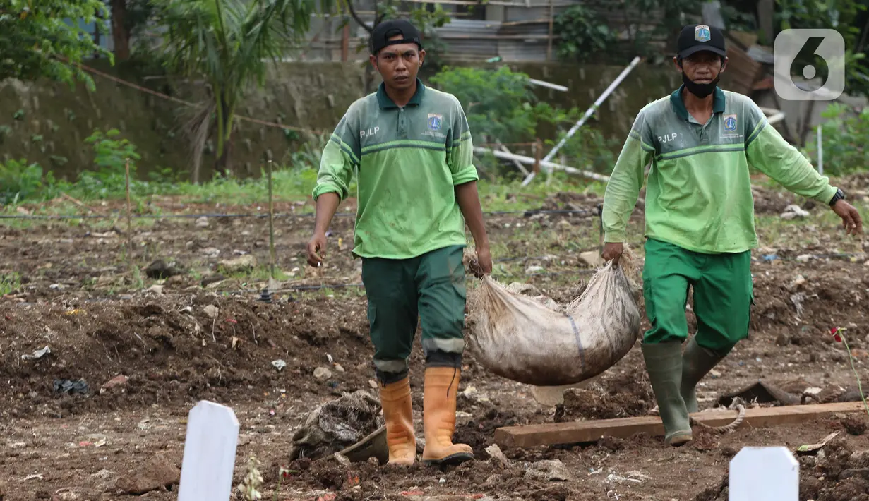 Petugas membersihkan area khusus pemakaman jenazah dengan protokol COVID-19 di TPU Srengseng Sawah Dua, Jakarta, Selasa, (2/2/2021). TPU Srengseng Sawah 2, saat ini mulai menerima pemakaman jenazah protokol COVID-19 dengan kapasitas 1.020 petak. (Liputan6.com/Helmi Fithriansyah)
