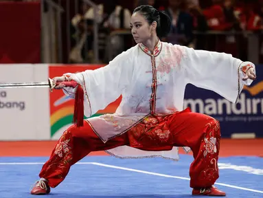 Atlet Wushu Indonesia, Lindswell Kwok saat beraksi pada Asian Games  di JIExpo, Jakarta, Senin, (20/8). Lindswell Kwok berhasil menyumbang emas kedua untuk Indonesia di Asian Games 2018. (AP Photo/Aaron Favila)