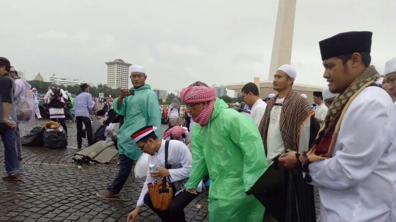Aa Gym berinisiatif memunguti sampah yang masih tersisa di lapangan Monas. 