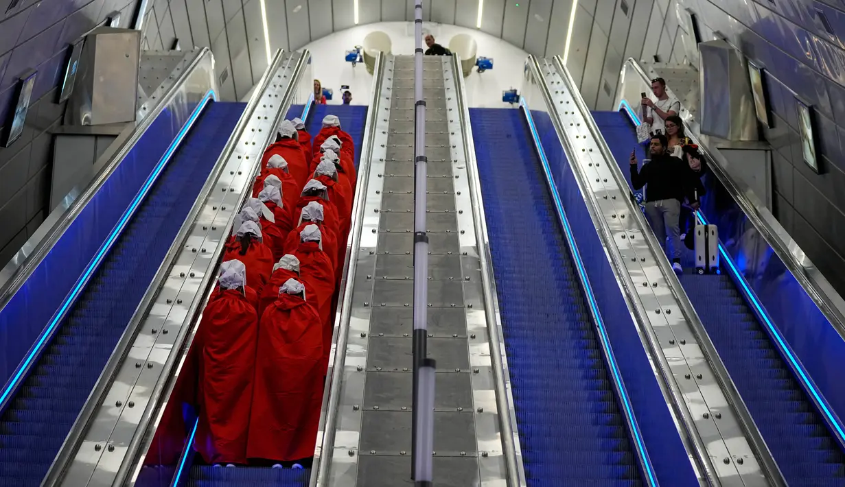 Pengunjuk rasa yang mendukung hak-hak perempuan berpakaian seperti karakter dari serial TV "The Handmaid's Tale" saat melakukan perjalanan untuk memprotes rencana pemerintah baru Perdana Menteri Benjamin Netanyahu untuk merombak sistem peradilan di sebuah stasiun kereta api di Yerusalem, Israel, 1 Maret 2023. Mengacu pada fenomena yang berkembang, harian Inggris The Guardian menggambarkan penampilan para pelayan sebagai salah satu simbol paling kuat dari protes feminis kontemporer. (AP Photo/Ohad Zwigenberg)