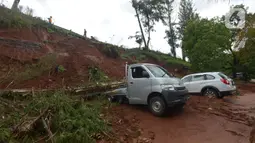 Dua mobil tertimpa longsoran dinding ruas jalan Tol JORR Cikunir, Bekasi, Jawa Barat, Kamis (2/1/2020). Hujan deras pada malam Tahun Baru 2020 membuat sejumlah titik jalan tol rawan longsor dan banjir. (merdeka.com/Imam Buhori)