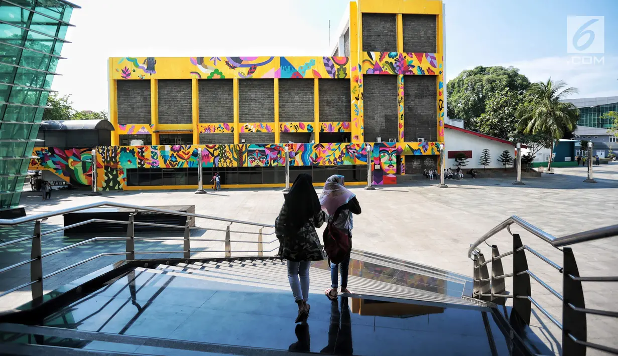 Warga berjalan di dekat karya seni Mural di Taman Ismail Marzuki (TIM), Jakarta, Selasa (11/9). Mural tersebut dibuat untuk mempererat kerjasama antara Pemprov DKI dengan Kedutaan Besar Kolombia dalam bidang seni perkotaan. (Liputan6.com/Faizal Fanani)