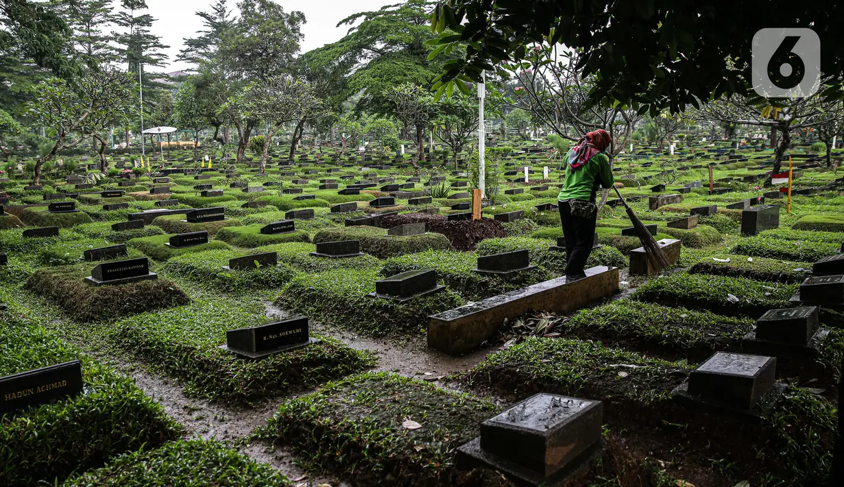 Petugas kebersihan menyapu area makam di Tempat Pemakaman Umum (TPU) Karet Bivak, Jakarta, Minggu (27/6/2021). Pemerintah Provinsi DKI Jakarta membatasi aktivitas dan kunjungan ke TPU hingga 5 Juli 2021 untuk menekan penularan COVID-19. (Liputan6.com/Faizal Fanani)