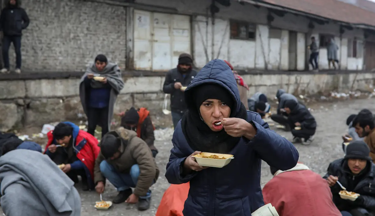 Sejumlah imigran makan makanan gratis di Belgrade, Serbia, Kamis (22/12). (REUTERS / Marko Djurica)