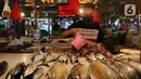 Pedagang menyirami ikan jualannya agar kelihatan segar di Pasar Senen, Jakarta, Jumat (8/1/2021). Harga jual ikan laut saat ini mengalami lonjakan yang diakibatkan kurangnya pasokan ikan dari nelayan ke pedagang di pasar tradisional. (merdeka.com/Imam Buhori)