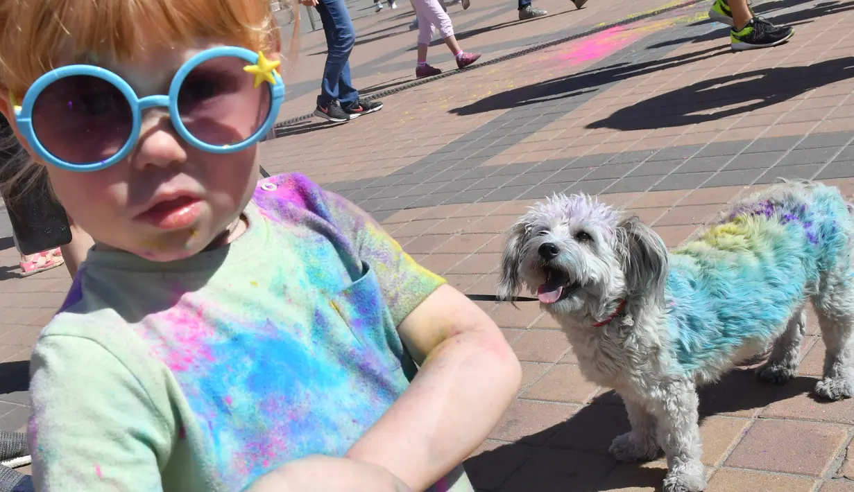 Seorang anak kecil dan anjingnya dipenuhi bubuk warna-warni saat mengikuti Kyiv Color Run di Kiev, Ukraina, Minggu (10/6). The Color Run diluncurkan dan diselenggarakan pertama kali pada Januari 2012 di Amerika Serikat. (AFP PHOTO/Sergei SUPINSKY)