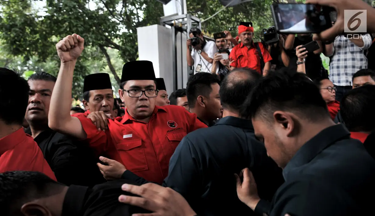 Suasana saat elite dan massa PDIP  terlibat saling dorong dengan petugas keamanan saat hendak masuk untuk mengantarkan pengurus DPP mendaftarkan bakal caleg.ke Gedung KPU, Jakarta, Selasa (17/7). (Merdeka.com/ Iqbal S. Nugroho)