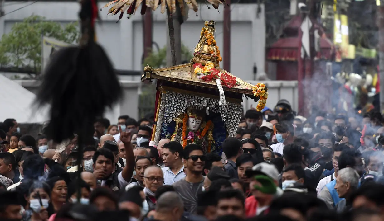 Orang-orang mengambil bagian dalam prosesi ketika para imam membawa Seto Machindranath, dewa pelindung Nepal, selama festival kereta di Kathmandu (9/4/2022). (AFP/Prakash Mathema)