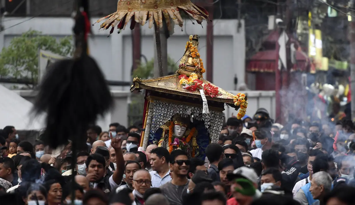Orang-orang mengambil bagian dalam prosesi ketika para imam membawa Seto Machindranath, dewa pelindung Nepal, selama festival kereta di Kathmandu (9/4/2022). (AFP/Prakash Mathema)