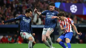 Striker Atletico Madrid, Julian Alvarez, berebut bola dengan dua pemain Arsenal Declan Rice dan Martin Zubimendi dalam pertandingan sepak bola semifinal Liga Champions leg pertama antara Club Atletico de Madrid dan Arsenal di stadion Metropolitano di Madrid pada Kamis (30/4/2026). (Javier SORIANO / AFP)