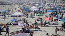 Pengunjung berkumpul di Pantai Newport selama masa pandemi covid-19 di California pada Minggu (24/5/2020). Warga Amerika Serikat mengabaikan pedoman jarak sosial dan memilih berjemur di pantai ketika angka kematian akibat virus corona di negara itu mendekati 100.000 orang. (AP/Marcio Jose Sanchez)