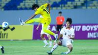 Pemain Timnas Malaysia, Dawud lmran Bin Rozlin, menendang bola saat berebut bola dengan Timnas Indonesia U-17, Girly Andrade Guevara, pada laga kedua Grup A Piala AFF U-17 2026 di Stadion Gelora Joko Samudro, Gresik, Jawa Timur, Kamis (16/4/2026) malam. (Bola.com/M Iqbal Ichsan)