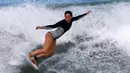 Peselancar wanita menunjukan aksinya menaklukan ombak selama mengikuti dalam kompetisi surfing di laut Mediterania di Ashdod, Israel, (17/11). (REUTERS/Amir Cohen)