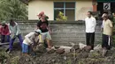 Presiden Joko Widodo atau Jokowi  meninjau pelaksanaan padat karya di Desa Kukuh, Kecamatan Marga, Tabanan, Bali, Jumat (23/2). Sebanyak 25 warga terlibat dalam pembangunan jalan produksi sepanjang 592 meter tersebut. (Liputan6.com/Pool/Biro Pers Setpres)