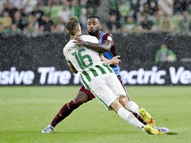 Pemain Trabzonspor, Stefano Denswil, berusaha menghadang pergerakan pemain Ferencvaros, Kristoffer Zachariassen, pada laga Liga Europa di  Groupama Arena, Jumat (9/9/2022). (Tamas Kovacs/MTI via AP)