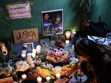 Seorang wanita meletakkan lilin di altar sebagai penghormatan bagi jurnalis yang tewas akibat serangan Israel di Jalur Gaza, saat menghadiri doa bersama di Mexico City pada 12 Agustus 2025. (Yuri CORTEZ/AFP)