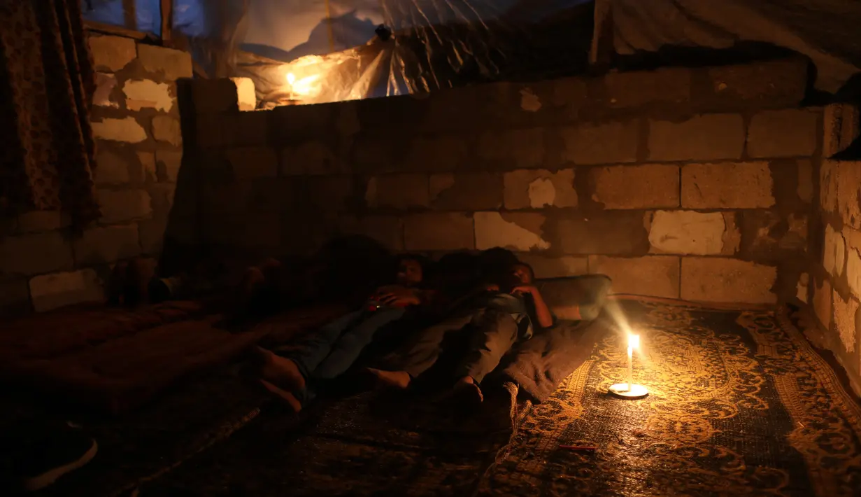 Warga Palestina terlihat di dalam rumah mereka saat pemadaman listrik terjadi di Kota Khan Younis, Jalur Gaza selatan, pada 18 Agustus 2020. Satu-satunya pembangkit listrik di Jalur Gaza telah sepenuhnya berhenti beroperasi akibat kehabisan bahan bakar. (Xinhua/Yasser Qudih)