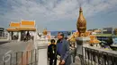 Pengunjung memasuki kawasan kuil Golden Budha di kota Bangkok, Thailand, Sabtu (17/12). Salah satu biksu yang ada di kuil tersebut memprediksi hasil laga final kedua Piala AFF 2016 antara Thailand melawan Indonesia. (Liputan6.com/Helmi Fithriansyah)