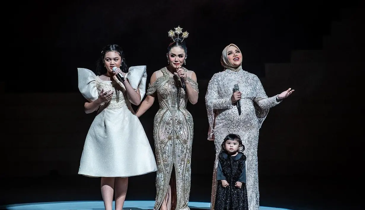 Dalam penampilannya, sosok mungil menggemaskan, yakni Ameena yang turut hadir di panggung yang sama tak luput dari perhatian.  Mereka tampil kompak mengenakan gaun yang glamor nuansa hitam dan emas. [Instagram/aurelie.hermansyah]
