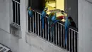 Sekawanan burung macaw (sejenis beo) berada di balkon sebuah gedung apartemen di Caracas pada 18 November 2018. Setiap sore, puluhan macaw liar berwarna-warni berduyun-duyun ke balkon dan teras tempat warga menaruh makanan untuk mereka. (YURI CORTEZ/AFP)