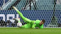 Kiper Kroasia,&nbsp;Dominik Livakovic&nbsp;melakukan penyelamatan saat penalti melawan Jepang pada laga 16 besar Piala Dunia 2022 yang berlangsung di&nbsp;Al-Janoub Stadium, Senin (05/12/2022). (AFP/Andrej Isakovic)