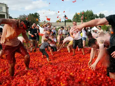 Orang-orang saling melempar tomat ketika berpartisipasi dalam festival 'Tomatina' atau perang tomat di St.Petersburg, Rusia, Minggu (18/8/2019). Tomatina atau perang tomat adalah festival Spanyol, dan tahun ini merupakan pertama kalinya dirayakan di Rusia. (AP Photo/Dmitri Lovetsky)