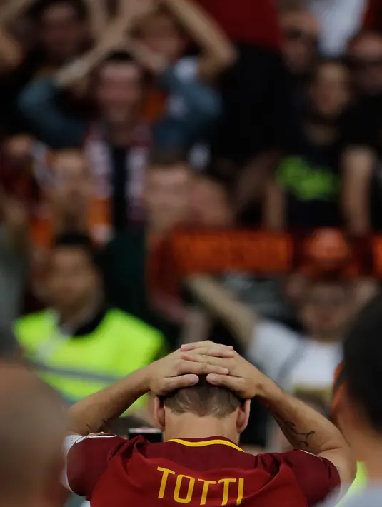 Francesco Totti bereaksi setelah memberi salam terakhir kepada suporter AS Roma usai melawan Genoa di Stadion Olimpico, Minggu (28/5). Totti yang telah berusia 40 menyatakan gantung sepatu setelah musim ini berakhir (AP Photo/Alessandra Tarantino)