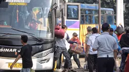 Penumpang turun dari bus Antar Kota Antar Provinsi (AKAP) di Terminal Kampung Rambutan, Jakarta, Selasa (19/6). Terdapat 691 bus kedatangan hingga siang ini. (Liputan6.com/Faizal Fanani)