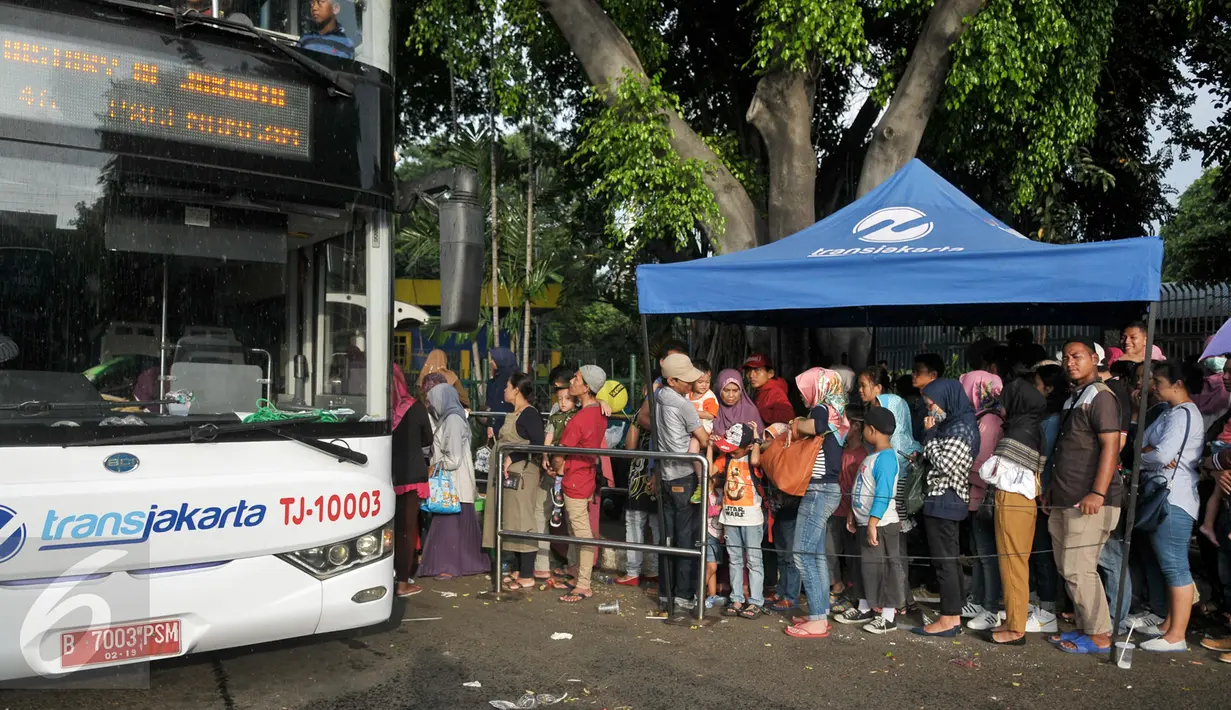 Antrean penumpang menaiki bus tingkat wisata di depan halte Masjid Istiqlal, Jakarta, Minggu (30/4). Warga memanfaatkan hari libur panjang mereka dengan berkeliling Jakarta menggunakan bus tingkat ini secara gratis. (Liputan6.com/Yoppy Renato)