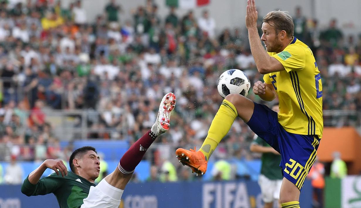 Pemain Meksiko, Edson Alvarez (kiri) menghalau bola dari kejaran pemain Swedia, Ola Toivonen pada laga grup F Piala Dunia 2018 di Yekaterinburg Arena, Yekaterinburg, Rusia, (27/6/2018).  Swedia menang telak 3-0 atas Meksiko. (AP/Martin Meissner)