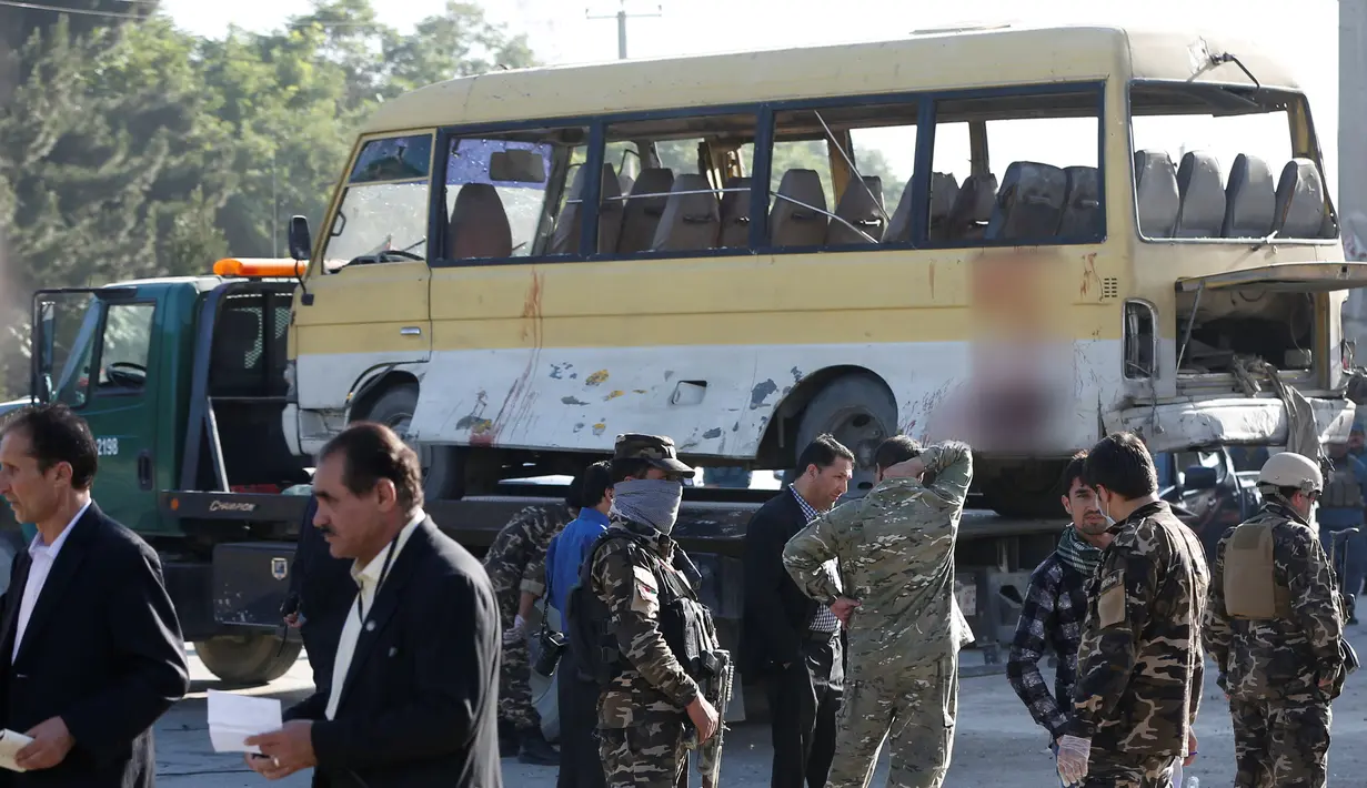 Salah satu bus yang terkena serangan bom di evakuasi petugas di pinggiran barat Kabul, Afghanistan, Kamis (30/6). Sebanyak 27 orang dikabarkan tewas dalam peristiwa naas tersebut. (REUTERS/ Omar Sobhani)