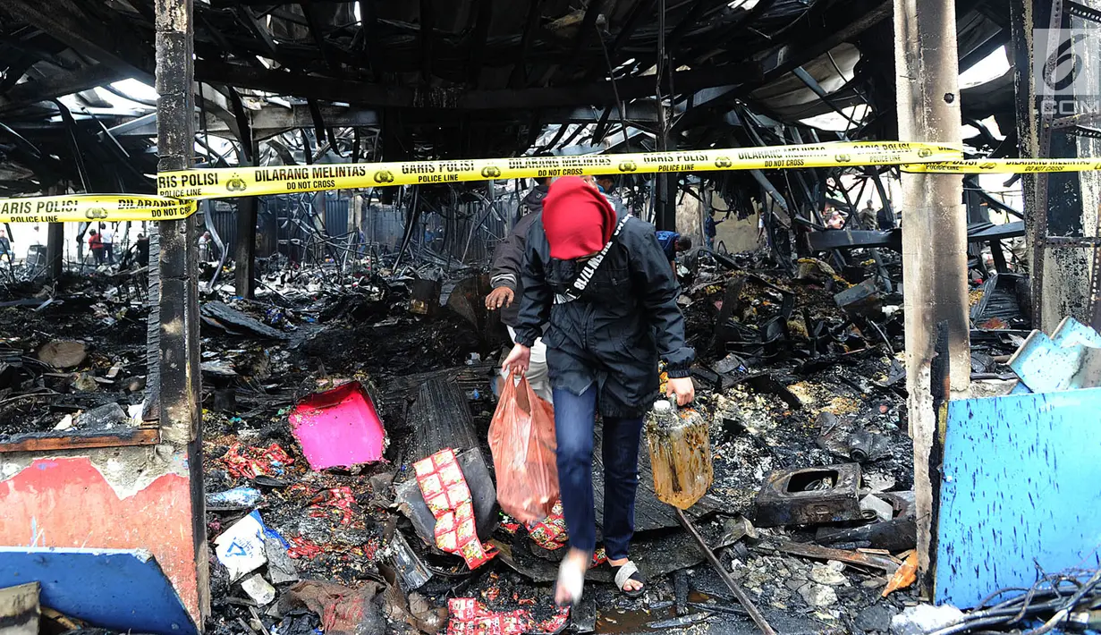 Pedagang mencari sisa barang dagangan usai kebakaran melanda Pasar Blok A Kebayoran Baru, Jakarta Selatan, Rabu (6/3). Diperkirakan sebanyak 414 unit kios hangus terbakar. (merdeka.com/Arie Basuki)