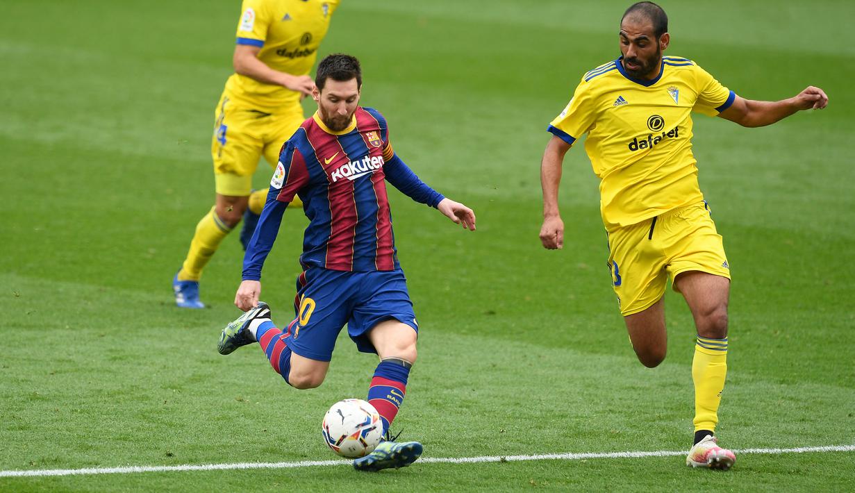 Lionel Messi (kiri) tidak menyia-nyiakan peluang emas dan sukses mencetak gol dengan membidik sisi kiri gawang Cadiz. (Foto: AFP/Josep Lago)
