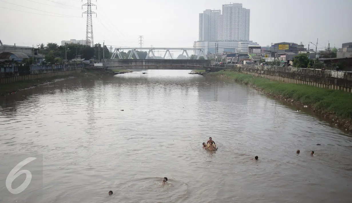 Sejumlah anak berenang di aliran kali besar Banjir Kanal Barat, Jakarta, Sabtu (11/3). Anak-anak ini mengaku nekat berenang karena tidak mampu mengakses fasilitas kolam renang ataupun sarana bermain lainnya. (Liputan6.com/Faizal Fanani)