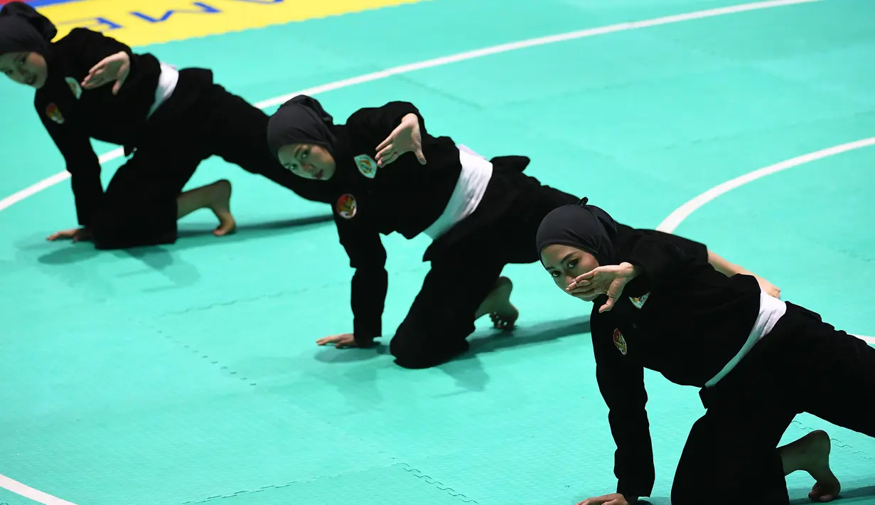 Tim pencak silat seni beregu putri Indonesia, Pramudita Yuristya (kiri), Lutfi Nurhasanah (tengah) dan Gina Tri Lestari (kanan) tampil dalam babak final Asian Games 2018 di TMII, Jakarta, Rabu (29/8). (ANTARA FOTO/INASGOC/Melvinas Priananda/nak/18)