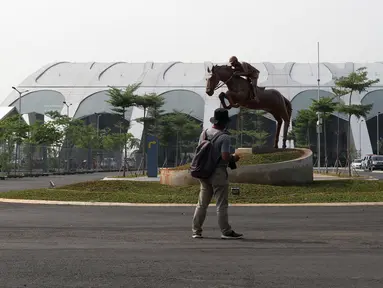 Pewarta melihat-lihat di salah satu pintu masuk kawasan Jakarta International Equestrian Park Pulomas, Jakarta, Kamis (2/8). JIEPP akan menjadi venue tiga cabang equestrian Asian Games 2018. (Liputan6.com/Helmi Fithriansyah)
