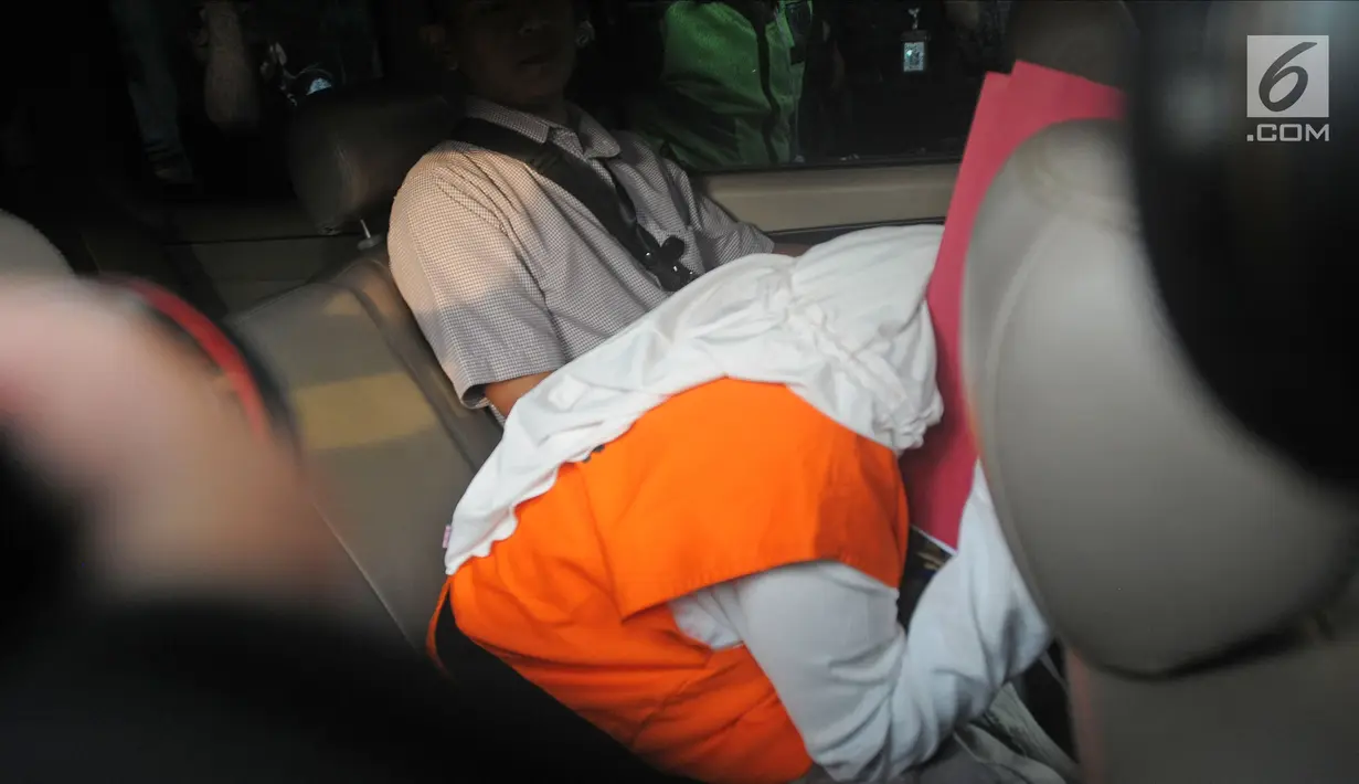 Anggota Komisi A DPRD Kebumen Dian Lestari menunduk dalam mobil musai menjalani pemeriksaan di Gedung KPK, Jakarta, Selasa (13/2). Lima orang lainnya sudah lebih dahulu ditetapkan sebagai tersangka sesaat setelah OTT. (Liputan6.com/Herman Zakharia)