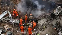 Petugas pemadam kebakaran dan penyelamat saat berupaya membersihkan reruntuhan bangunan yang hancur akibat ledakan yang terjadi Rio de Janeiro, Brasil, Senin (19/10/2015). Peristiwa ini menewaskan 7 orang dan lainnya cedera. (REUTERS/Pilar Olivares)