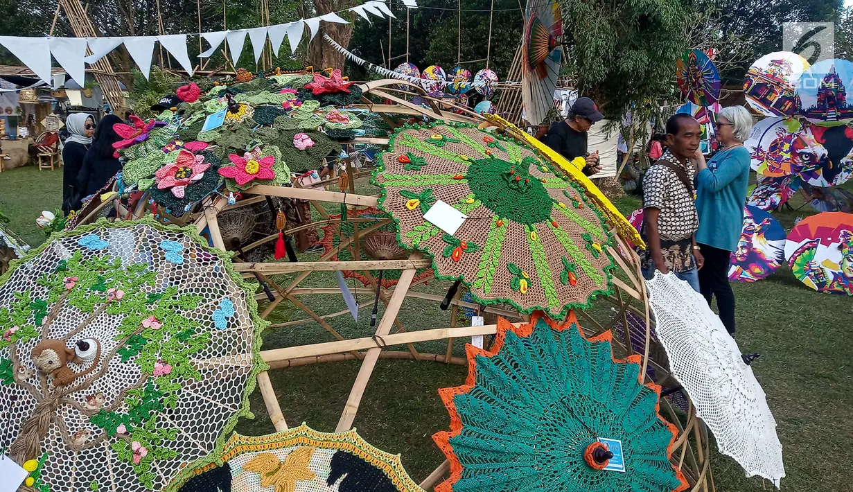 Pengunjung berpose di deretan payung selama Festival Payung Indonesia 2019 di Taman Garuda Mandala, Komplek Candi Prambanan, Kabupaten Klaten, Sabtu ( 7/9/2019). Festival Payung Indonesia 2019 telah berlangsung ke enam kalinya. (Liputan6.com/Gholib)