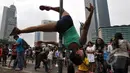 Pegiat 'Pole Dance' beraksi di tiang rambu lalu lintas saat Car Free Day di Bundaran HI, Jakarta, Minggu (18/1/2015). (Liputan6.com/Miftahul Hayat)
