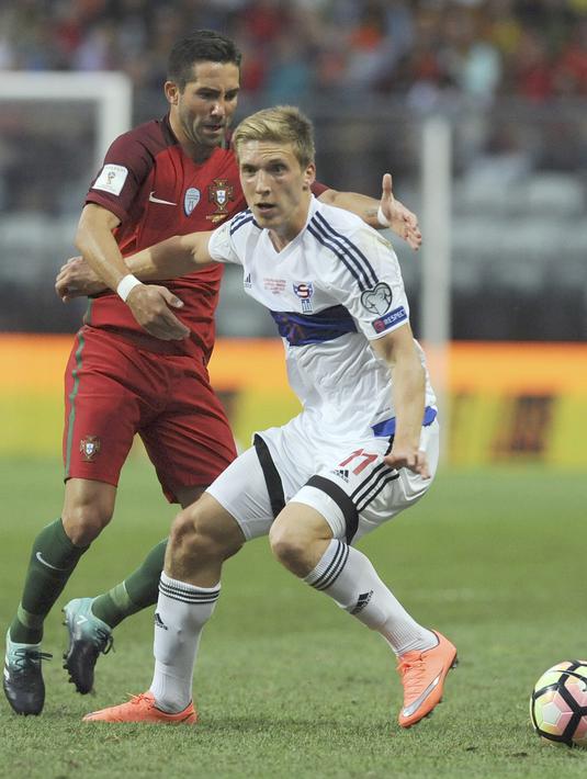 Pemain Kepulauan Faroe, Joan Edmundsson (kanan) berusaha melewati adangan pemain Portugal, Joao Moutinho pada laga Grup B Kualifikasi Piala Dunia 2018 di Bessa Stadium, Porto, (31/8/2017). Portugal menang 5-1. (AP/Paulo Duarte)