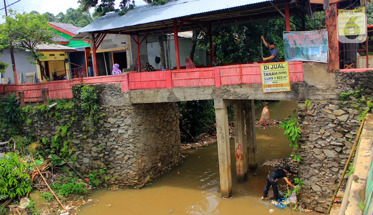 Warga kerja bakti membersihkan sampah yang terbawa aliran Kali Baru di bawah Jembatan Merah, Jalan Pitara Raya, Depok, Jawa Barat, Rabu (19/2/2020). Warga kerja bakti mengangkut sampah dari kali agar aliran sungai tetap lancar. (merdeka.com/Magang/Muhammad Fayyadh)
